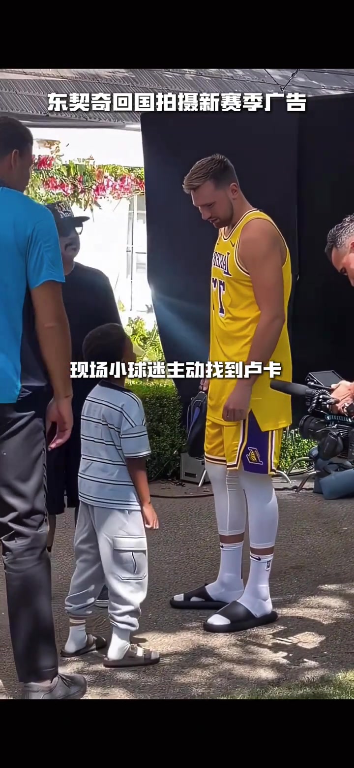 备战新赛季东契奇回国拍摄广告 身穿湖人77号和小球迷合影